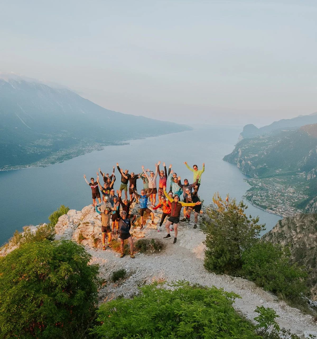 A group of runners on a rocky lookout high above Lake Garda